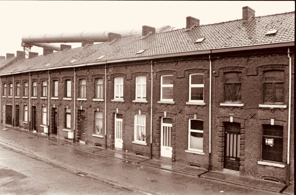 Sepia-toned image showcasing classic brick terraced houses on a rainy street.