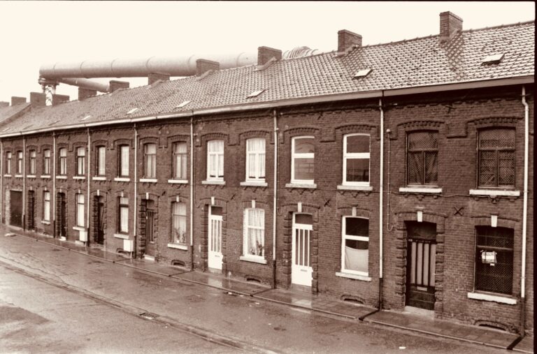 Sepia-toned image showcasing classic brick terraced houses on a rainy street.